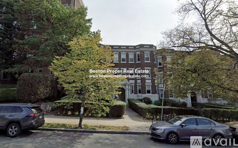 A street view with a car and a building with a sign that says Boston Proper Real Estate.