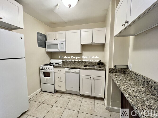 A kitchen with white appliances and cabinets.