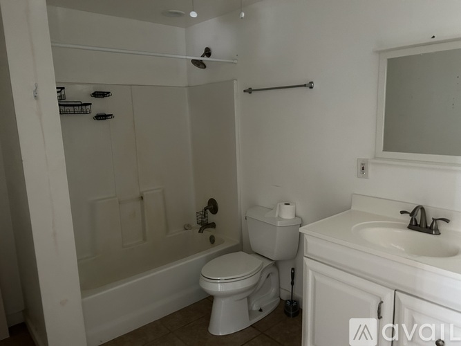 A white bathroom with a toilet, sink, and bathtub.