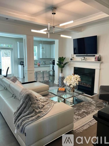 A modern living room with a white couch and a fireplace.