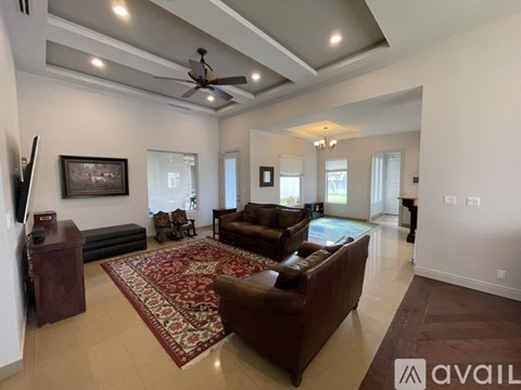 A living room with a brown couch and a rug.