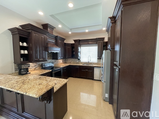 A kitchen with dark wood cabinets and granite countertops.