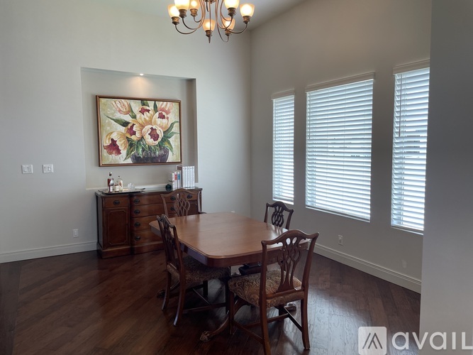 A dining room with a wooden table and chairs.