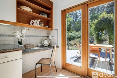 A kitchen with a chair and a table outside.