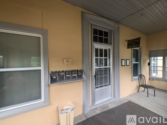 A room with a window, a door, and a sign on the wall.
