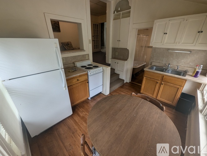 A kitchen with a white fridge, wooden cabinets, and a white stove.