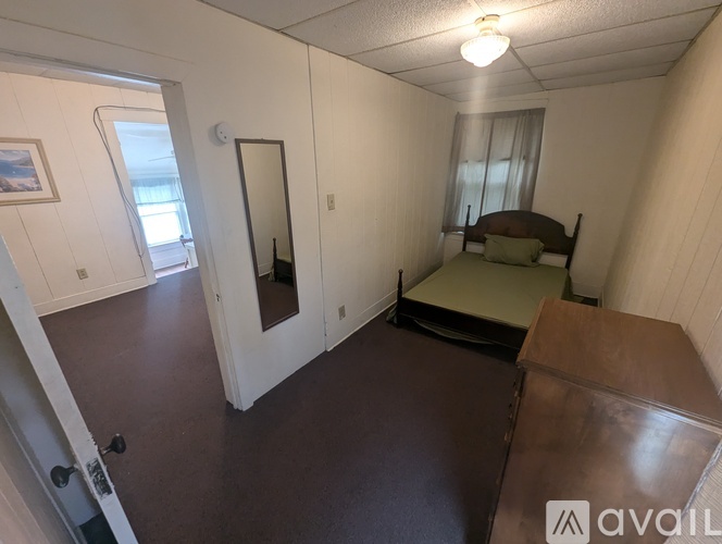 A bedroom with a bed, dresser, and mirror.
