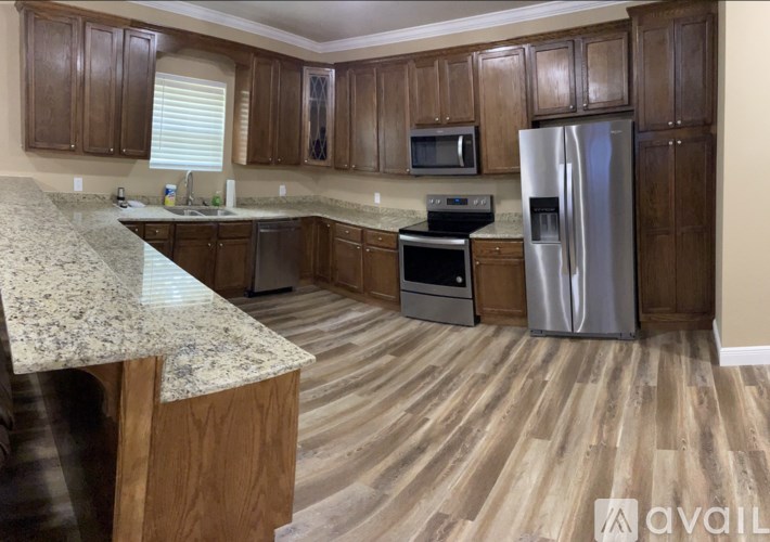 A kitchen with wooden cabinets and a granite countertop.