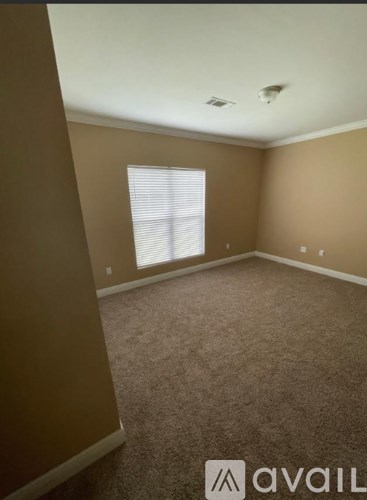 A room with a window and carpeted floor.