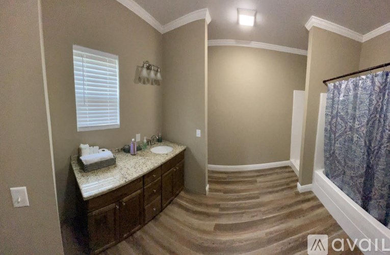 A bathroom with a large mirror and a window with blinds.