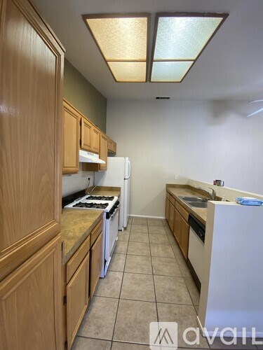 A kitchen with wooden cabinets and a white refrigerator.