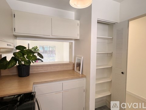 A kitchen with white cabinets and a wooden countertop.