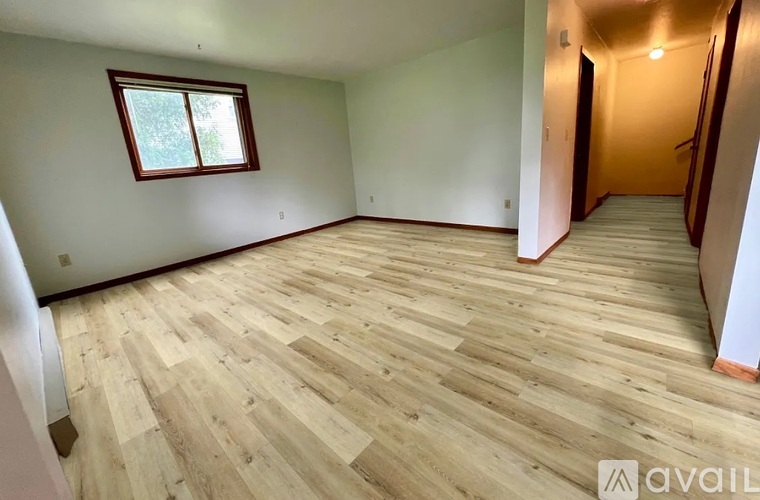 A room with wooden flooring and a window.