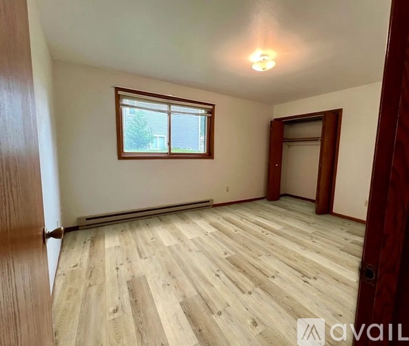 A room with wooden flooring and a window.