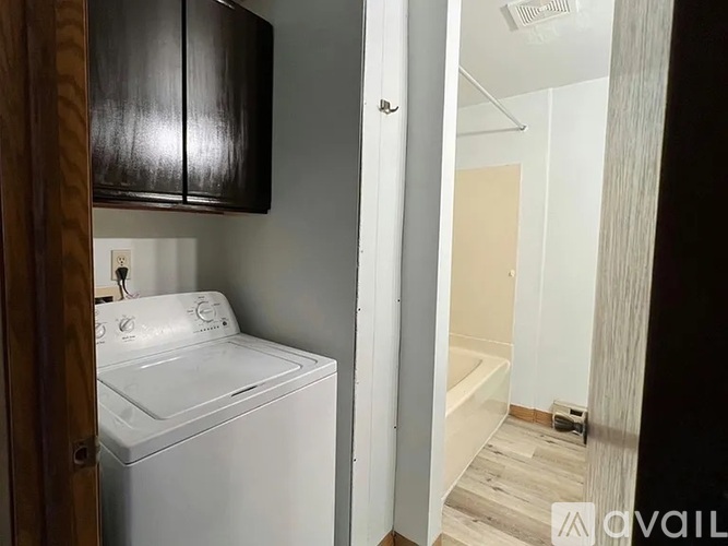 A white washing machine is in a small laundry room.
