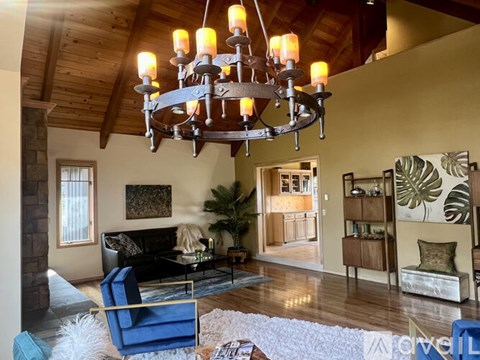 A living room with a blue chair and a chandelier.
