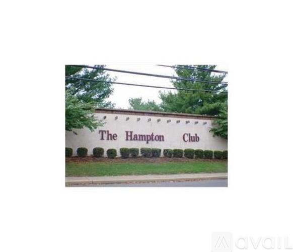 The Hampton Club sign is on a white building.