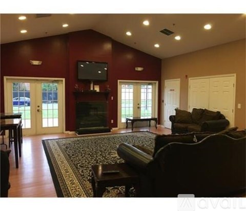 A living room with a fireplace and a television on the wall.