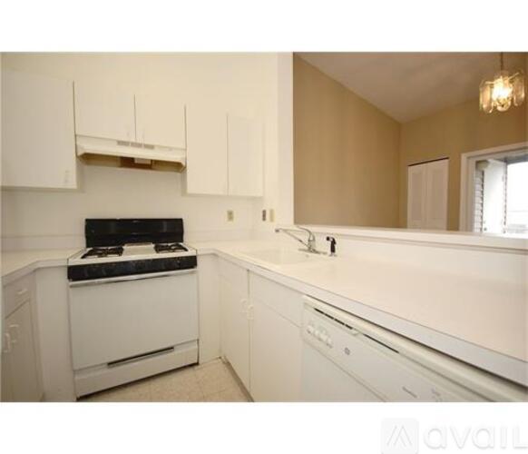 A kitchen with white appliances and cabinets.