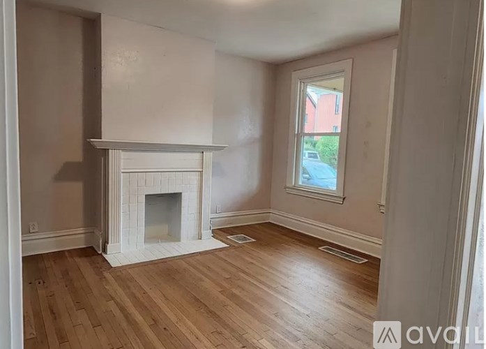 A room with a fireplace and wooden floors.