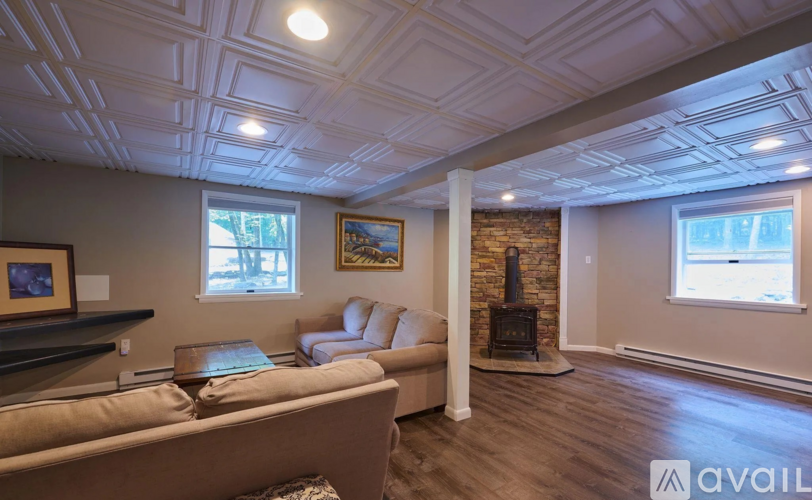 A living room with a couch, a coffee table, and a fireplace.