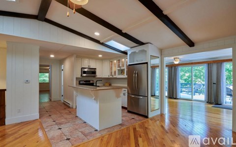 A kitchen with wooden floors and a white island.