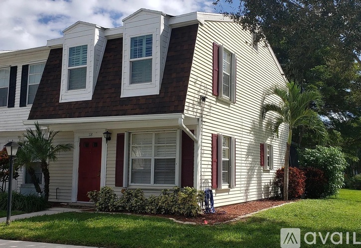 A white house with a red door and windows.