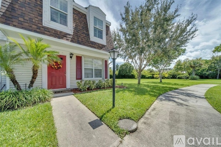 A house with a red door and a palm tree in front.
