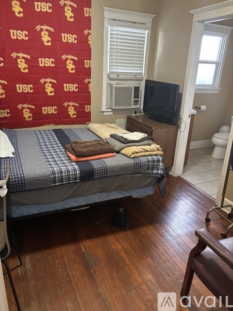 A bedroom with a USC curtain and a bed.