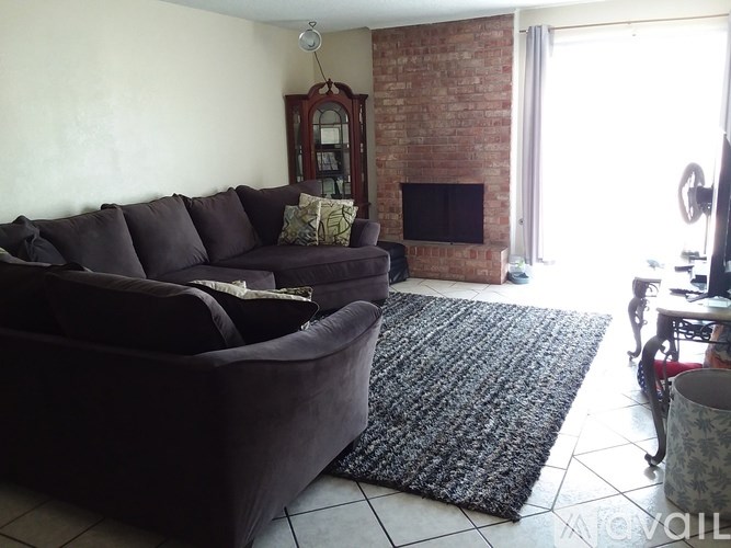 A brick house with a tree in front of it.