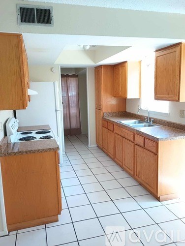 A kitchen with a granite counter top and a white stove.