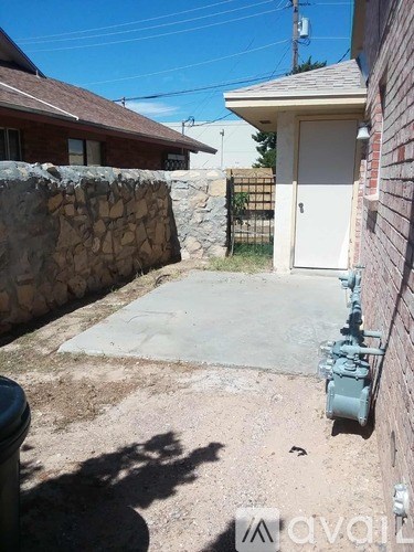 A backyard with a stone wall and a white door.