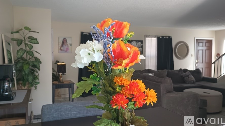 A vase of flowers sits on a table in a living room.