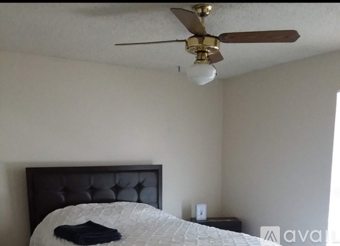 A bedroom with a bed, dresser, and window.