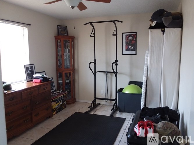 A room with a black chair and a black desk with a computer on it.