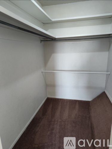 A room with a brown carpet and white walls.