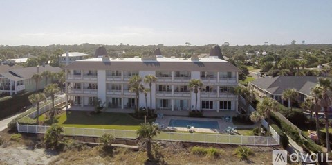 A large white house with a pool in the front yard.