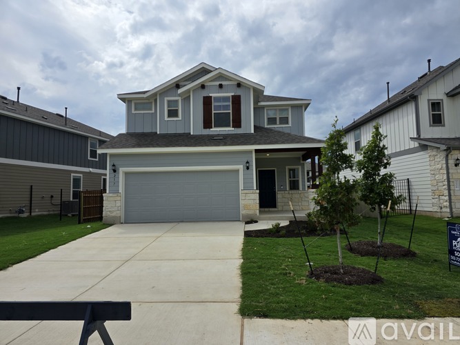 A house with a garage and a driveway in front of it.