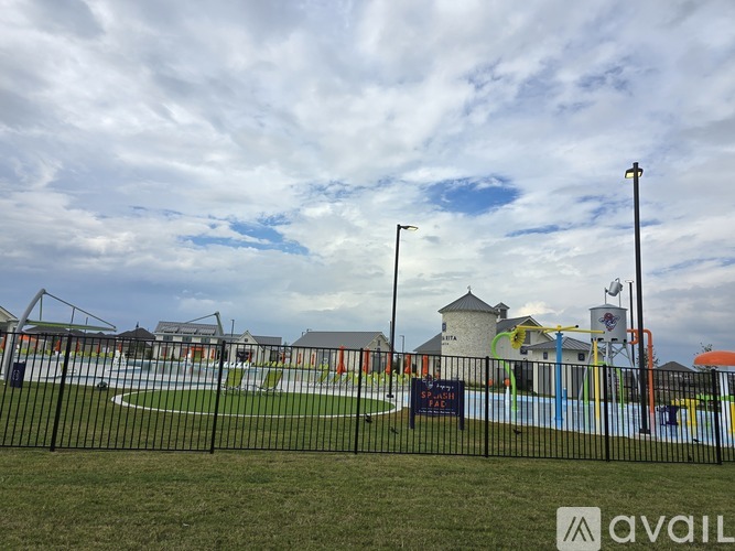 A playground with a black fence and a sign that says "AVAIL".