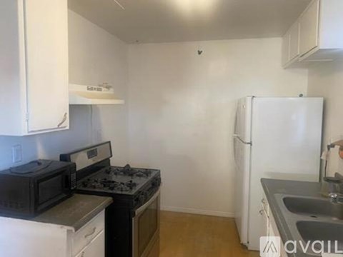 A kitchen with black appliances and white cabinets.