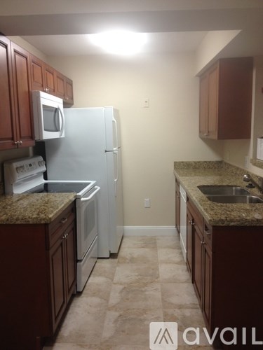 A kitchen with brown cabinets and a white refrigerator.
