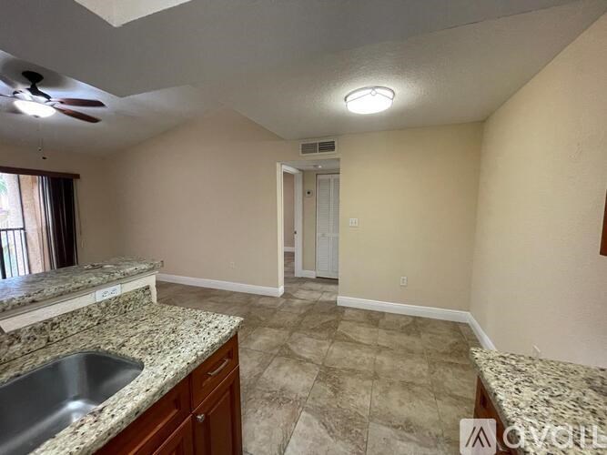 A kitchen with a sink and a ceiling fan.