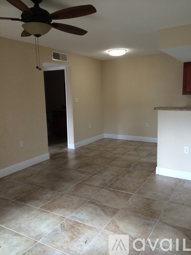 A room with a ceiling fan and tile flooring.