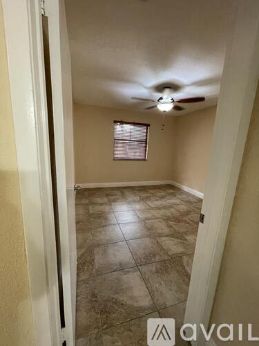 A room with a ceiling fan and tile flooring.