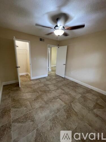 A room with a ceiling fan and tile flooring.