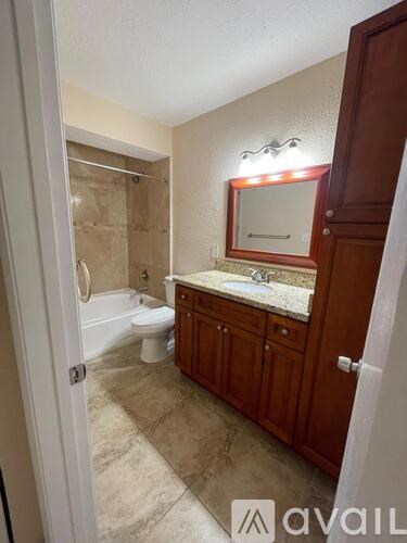 A bathroom with a toilet, sink, and mirror.