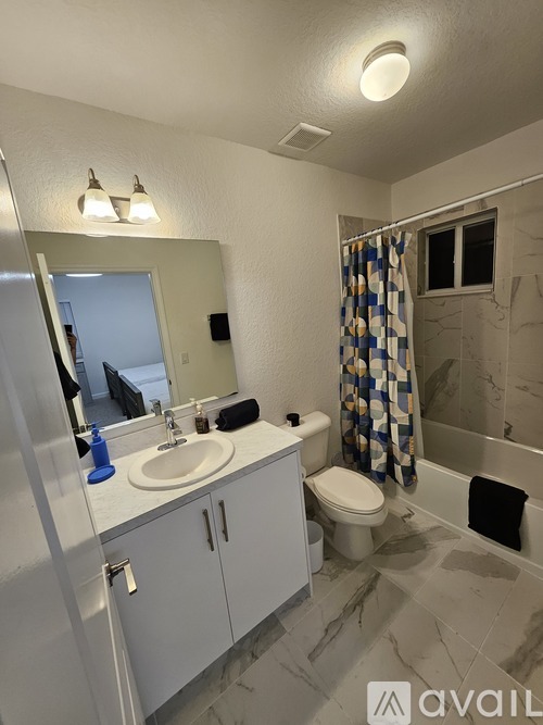 A bathroom with a toilet, sink, and mirror.