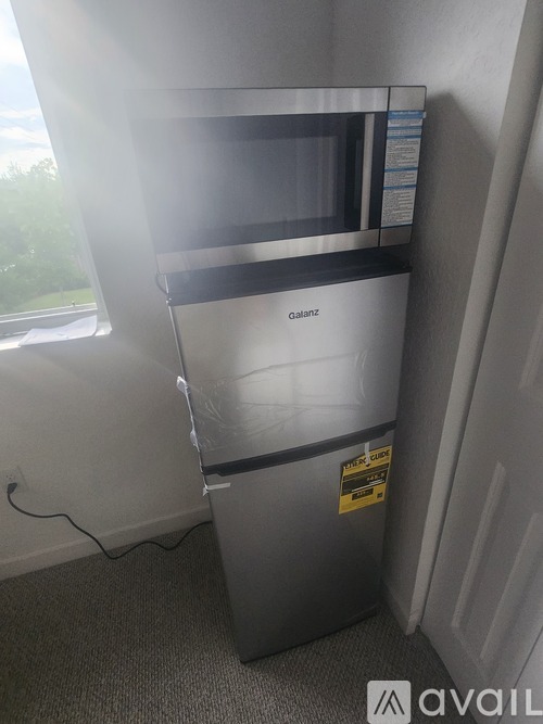 A Galanz microwave oven is on a stand in a room.