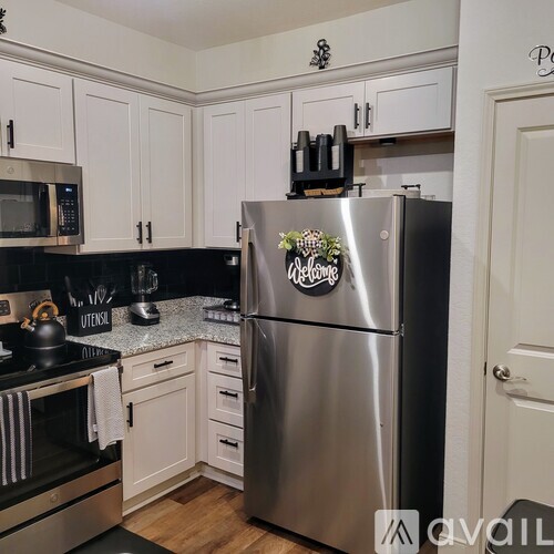 A kitchen with a stainless steel refrigerator in the center.