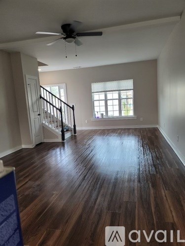 A room with wooden floors and a ceiling fan.